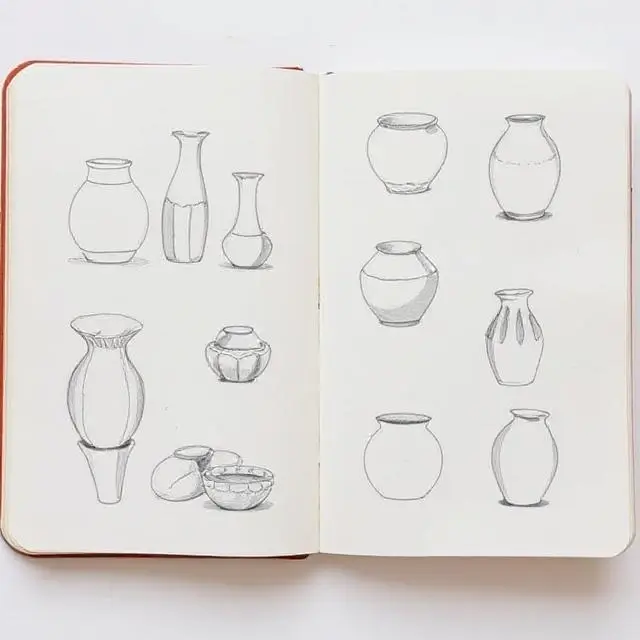 An open sketchbook showing drawings of ceramic forms.